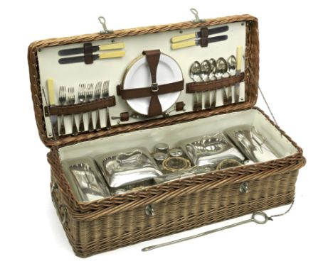 A six person Coracle picnic basket, circa 1920,woven wicker case with nickel plated brightwork and locking bar, the lid openi