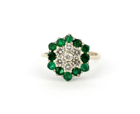 A hallmarked 18ct white gold cluster ring set with brilliant cut diamonds, approx. 0.50ct total, and round cut emeralds, (N).