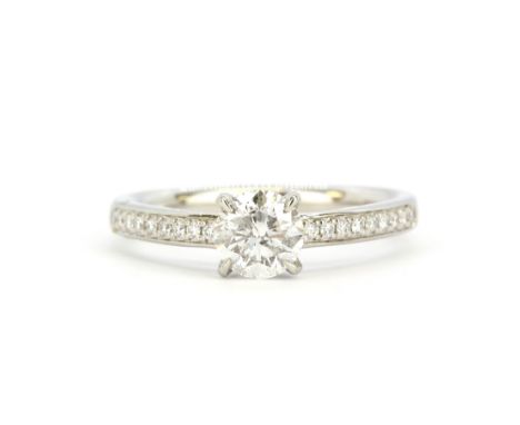 A 950 platinum solitaire ring set with a brilliant cut diamond and diamond set shoulders, with a WGI certificate, approx. 0.7