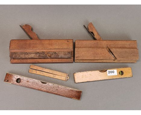 Two antique woodworking planes, three brass mounted spirit levels and a folding wooden ruler.