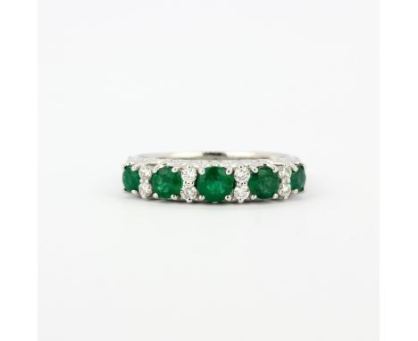 A 950 platinum half eternity ring set with round cut emeralds and brilliant cut diamonds, (M).