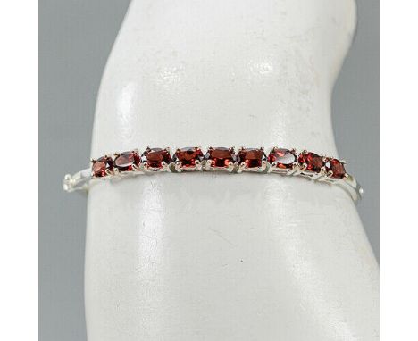 A 925 silver bangle set with oval cut garnets, L. 5.4cm.