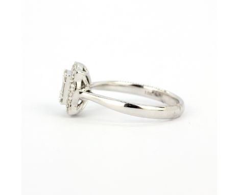 A hallmarked 18ct white gold ring set with baguette and round brilliant cut diamonds, (N).