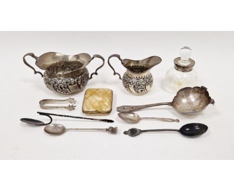 Edwardian silver cream jug and sugar basin, shouldered and scroll repousse, Chester assay, a silver tea strainer spoon, a sil