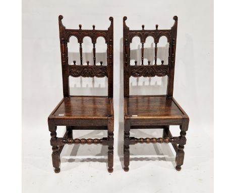 Pair of late 19th/early 20th century stained oak hall chairs, with spindle arched pierced backs, carved with foliate scrolls 