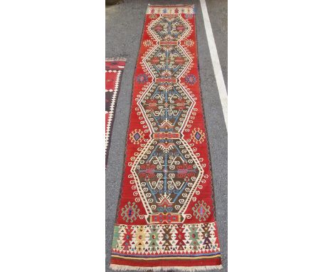 Caucasian kilim runner,&nbsp;woven with hexagonal foliate guls in cream, blue and red on a brown ground reserved within a dar