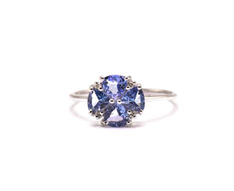 A 9ct white gold, diamond, and tanzanite flower head ring set with four trillion-cut tanzanites interspersed with four diamon