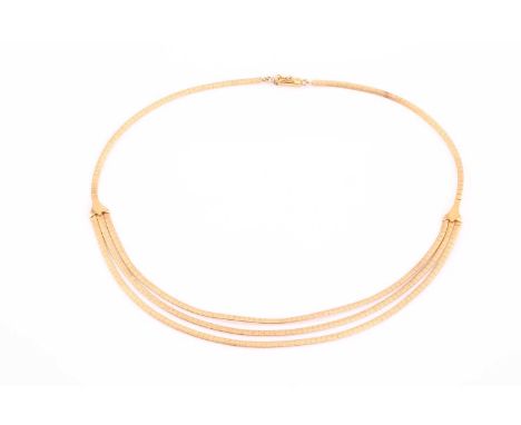 A three-stranded flat link chain in yellow precious metal, with an etched finish on one side, in contrast to the mirror finis