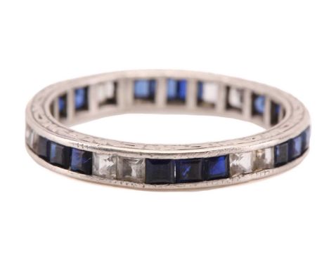 An eternity ring with sapphires, consisting of square step-cut sapphires and white stones channel set to a white precious met