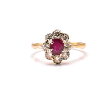 An 18ct gold and platinum diamond and ruby cluster ring, comprises an oval ruby in the centre, encircled with brilliant diamo