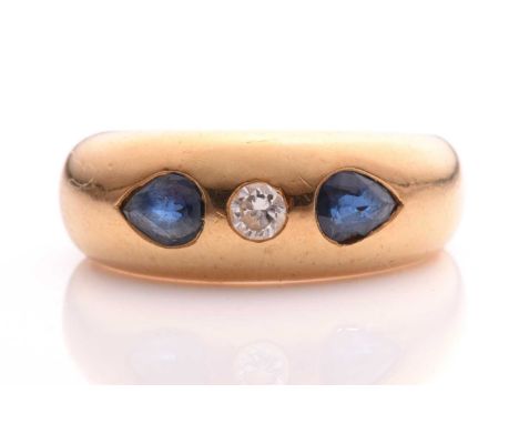 A sapphire and diamond gypsy ring, consisting of a brilliant diamond flush set in the middle flanked by two pear-shaped sapph