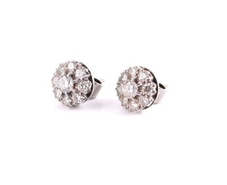 A pair of diamond cluster earrings, each comprising a larger brilliant diamond in the centre encompassed by eight smaller rou