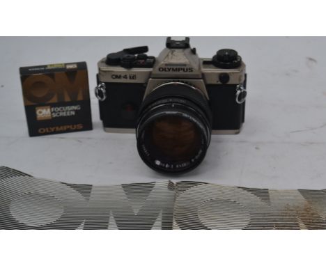 An Olympus OM-4 Ti slr camera serial no 1132287 with an attached Olympus G.Zuiko 55 mm lens and books.

UK, European & Worldw