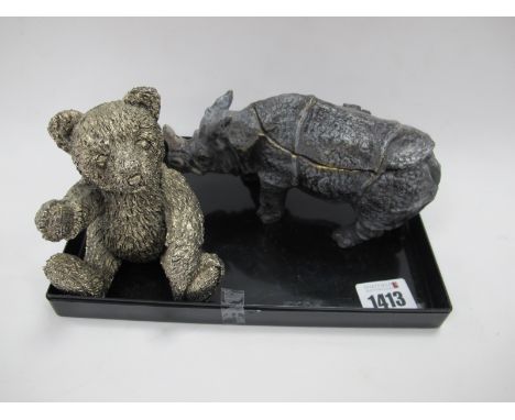 A Metal Inkwell as a Rhinosaurus, the hinged back lifting up to reveal two apertures, 16cm long, and a model bear. (2).