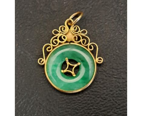 JADE SET PENDANTthe green jade disc in unmarked high carat gold mount with scroll detail, 2.7cm high and 2.2 grams