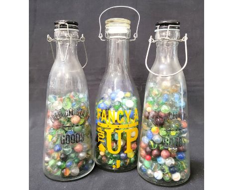 ASSORTED MARBLES HOUSED ACROSS THREE GLASS CARAFESthe marbles of various colours and patterns, one of the Carafes with "Fancy