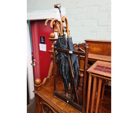 A corner stick stand and contents comprising five vintage umbrellas, two sticks and a a golf club.