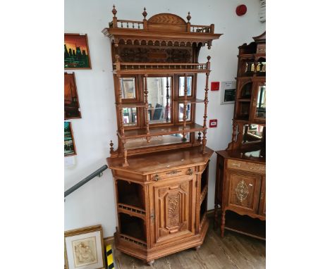 A late 19th century continental walnut mirror back side cabinet with carved panels, turned and fluted supports and brass moun