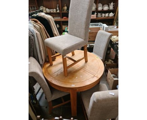 A modern light oak dining table and four chairs, diameter 105cm. 