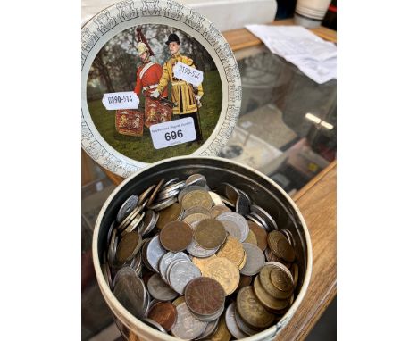 A vintage tin containing world coins. 