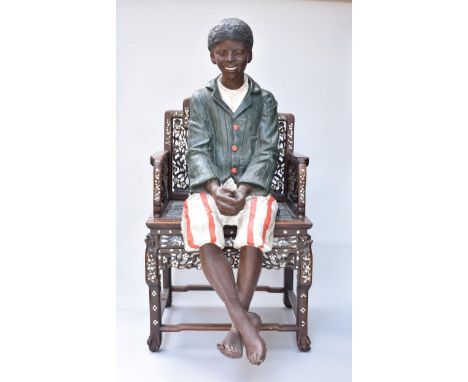 A Goldscheider style painted plaster lifesize African-American seated boy.&nbsp;&nbsp; 