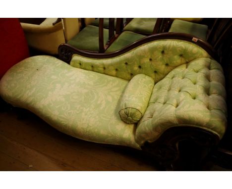 A Victorian carved walnut and button upholstered chaise longue.&nbsp; 