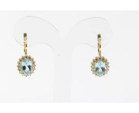 Yellow gold cluster earrings with light blue topaz and brilliant  cut diamonds, 750/000, gross w. 5.6 gr., length ca. 1.7 cm.