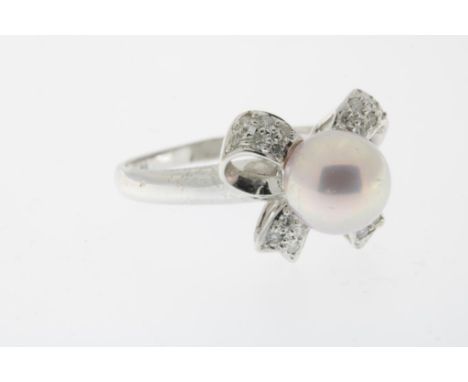 White gold ring set with a cultivated soft pink pearl on top of a  diamond set bow, gross w. 3.2 gr., seize 16.5.Witgouden ri