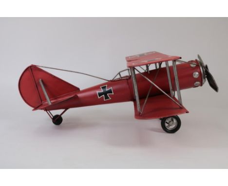 Red colored metal scale model of a biplane aircraft, h. 21, l. 58  cm.Rood beschilderd metalen schaalmodel van dubbeldekker v