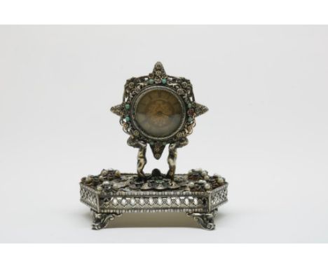 Gilded silver desk clock, carried by cupids on a hexagonal base,  eleboratly decorated with gemstones, simili, pearls and ena