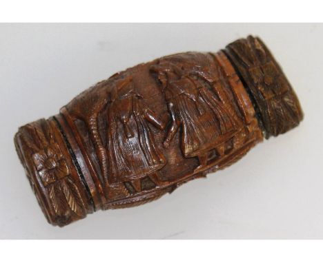 A good Coquilla nut snuff box, carved with figures. 8.5cms long, 3.5cms wide.