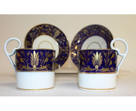 A pair of Derby coffee cups and saucers with blue and gilt bands.