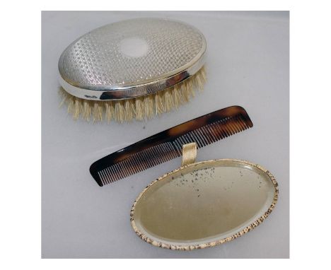 A travelling set with silver back brush, a mirror and a comb.
