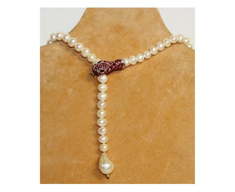 A pearl necklace with ruby set snake clasp.