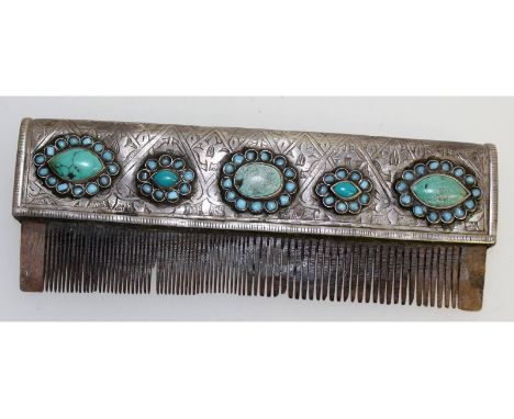 A Persian silver and turquoise comb, with horn teeth. 15cms long.