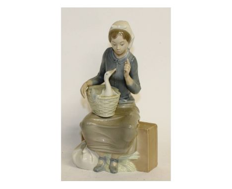 A Nao porcelain figure of a girl with a duck in a basket on her knee. 10.5ins high.