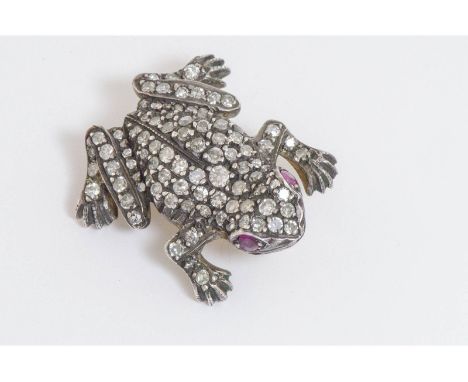 A diamond frog brooch set with ruby eyes.