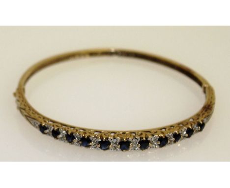 A good 19th century sapphire and diamond bangle, set in yellow gold with eleven sapphires.