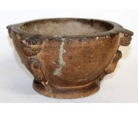 A rare, possibly 16th century, stone pestle with defaced heads. 7.5ins diameter.