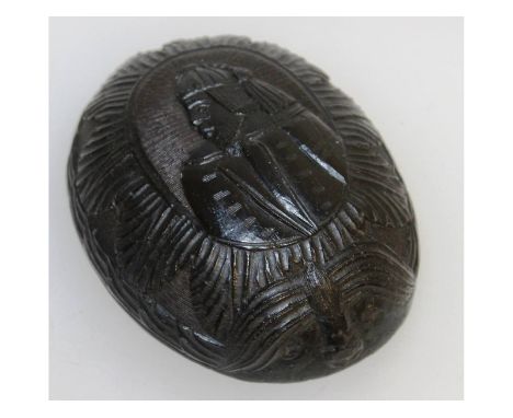 A South American carved coconut bowl, with a portrait of a man. 11cms long, 8cms wide.