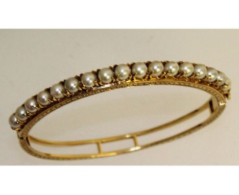 A superb 9ct yellow gold pearl set bangle.