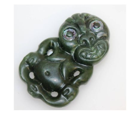 A rare round carved hardstone Tiki, with mother-of-pearl eyes. 7cms x 4.5cms.