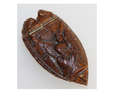 A good Coquilla nut snuff box, carved with a woman in an interior. 8cms long, 3.5cms wide.
