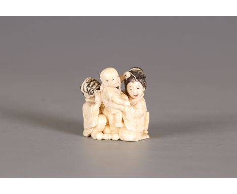 An ivory netsuke of a family, by RyugyokuJapan, Meiji period (1868-1912)Carved in the shape of man and a women playing with a