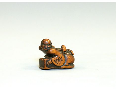 An 18th century wood Netsuke of rat catcherJapan, Edo period (1603-1868)Carved as a kneeling man leaning over a box, wearing 