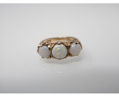 An Opal three stone Ring claw-set three round stones in 9ct gold, ring size J 1/2. 