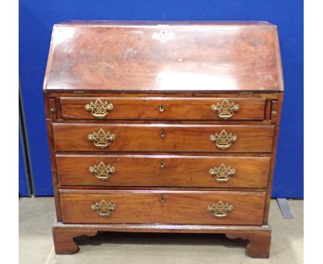 A Georgian mahogany Bureau with fall flap enclosing series of pigeon holes and drawers around central door, with replaced lea