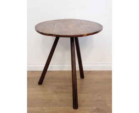 An antique elm circular Cricket Table on three splayed octagonal stick legs 2ft 9in D  Old woodworm holes in top, solid table