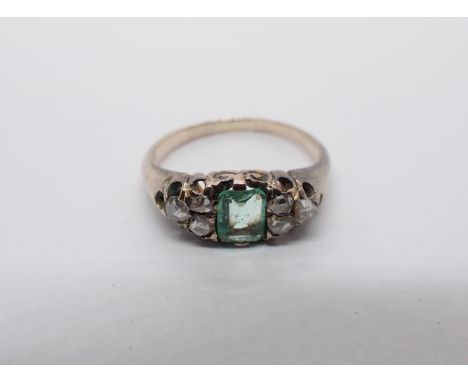 An Emerald and Diamond Ring pavé-set step-cut emerald between trios of rose-cut diamonds, ring size J 