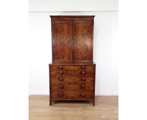 An early 19th Century yew wood Secretaire Bookcase, the upper section with raised moulded panelled doors enclosing shelves, t